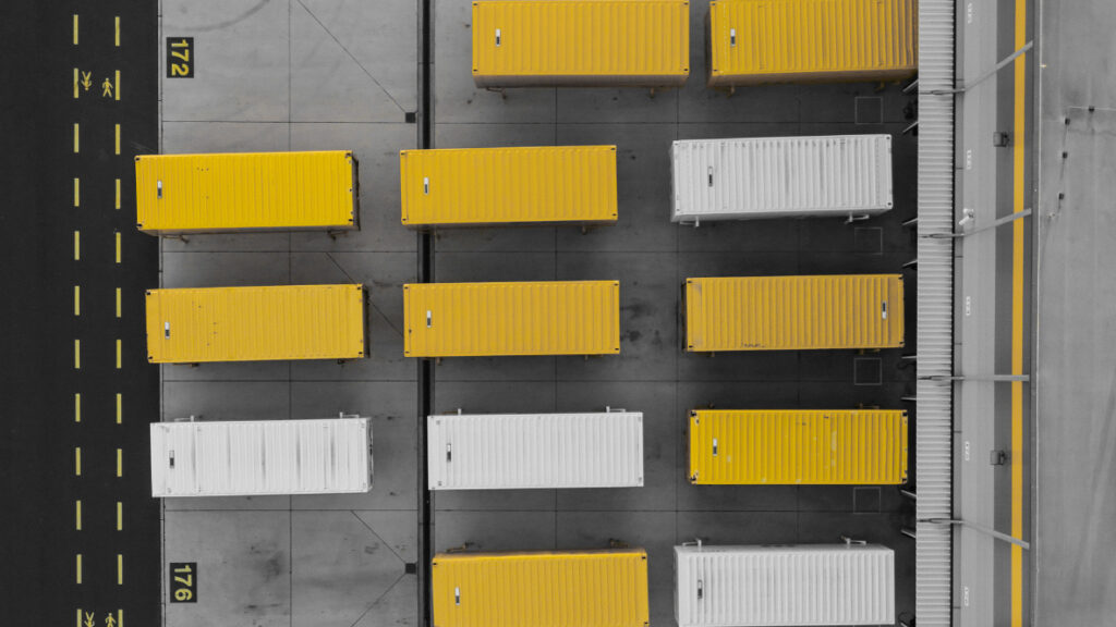 Attese dimezzate, valore raddoppiato: l’impatto del DL 73/2025 sulla logistica 2 Piazzale logistico visto dall’alto con container ordinati — esempio di gestione digitale dei tempi di carico e scarico con Time Slot Management di Transporeon in Italia