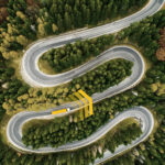 Camion su strada tortuosa immersa nel verde — simbolo dell’evoluzione AI e della logistica predittiva sviluppata da Transporeon