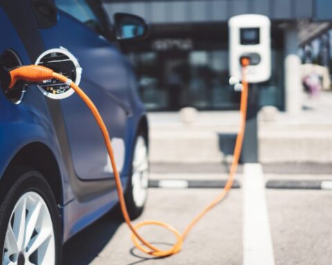 Auto elettrica in ricarica pubblica, simbolo della transizione energetica europea tra opportunità e criticità emergenti